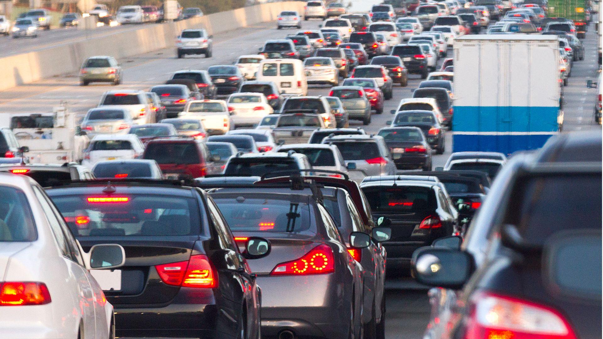 Heavy traffic on a multi-lane highway, with cars and trucks densely packed, creating a congested scene.