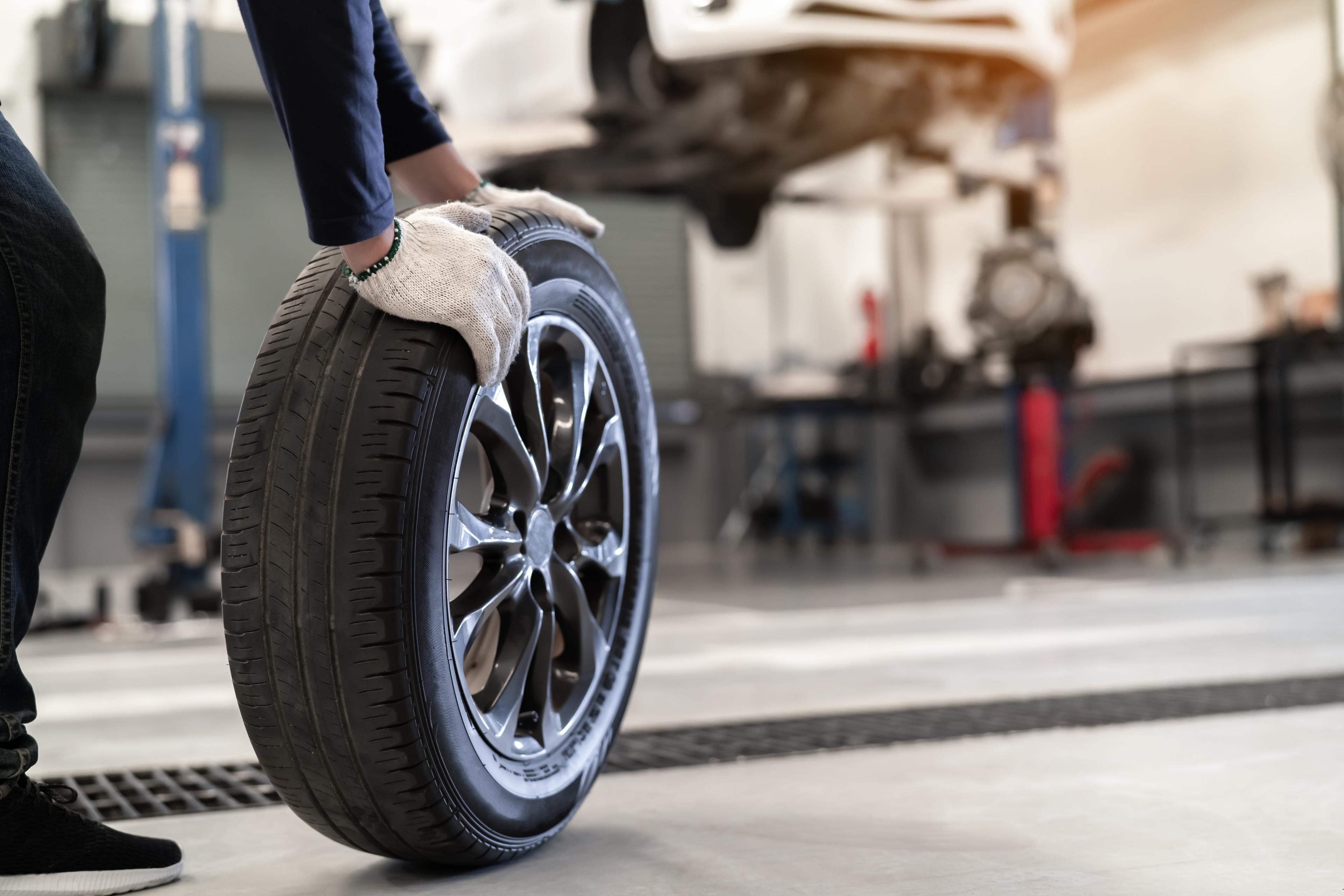 Mechanic wheels out a new tyre