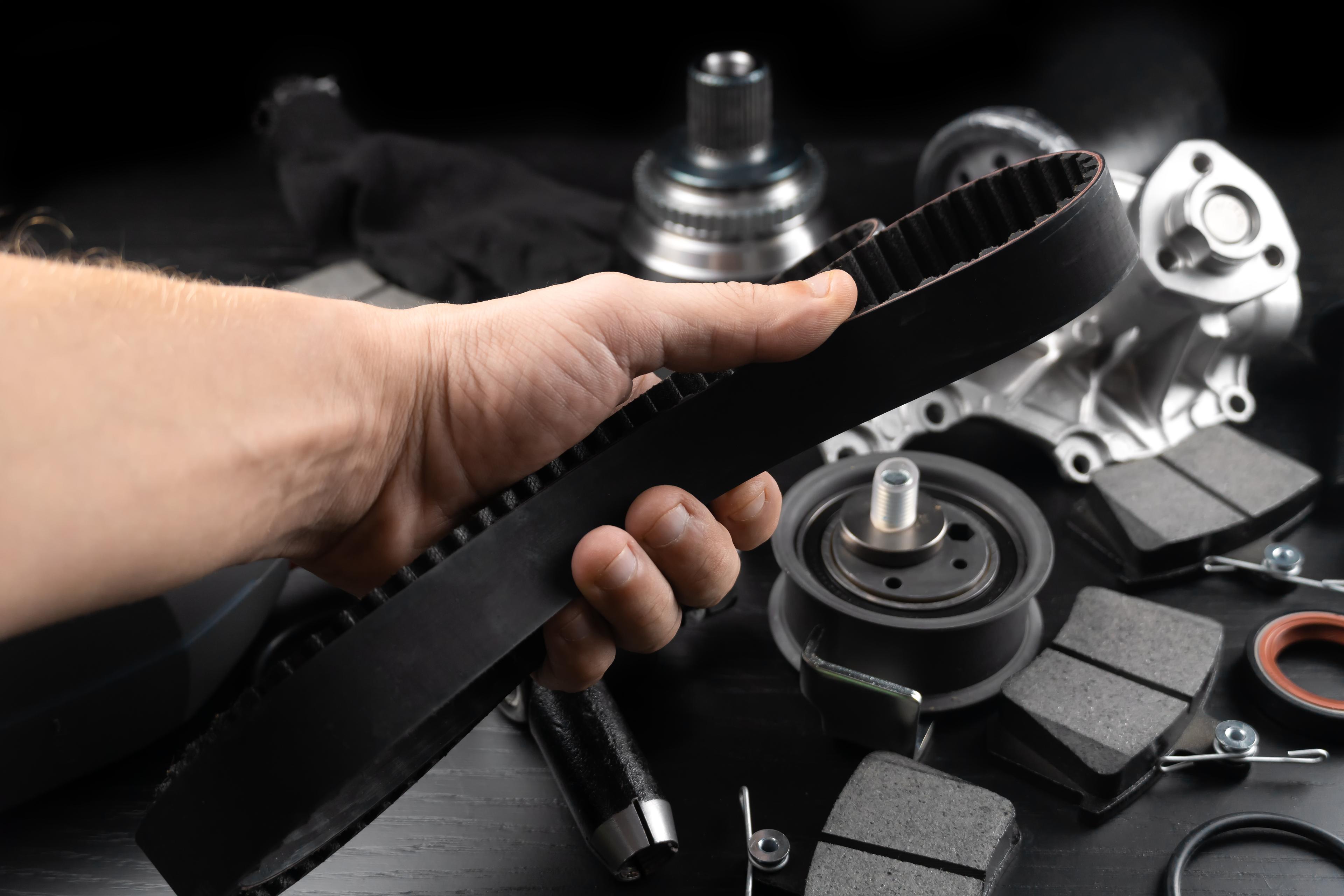 Mechanic holds a timing belt