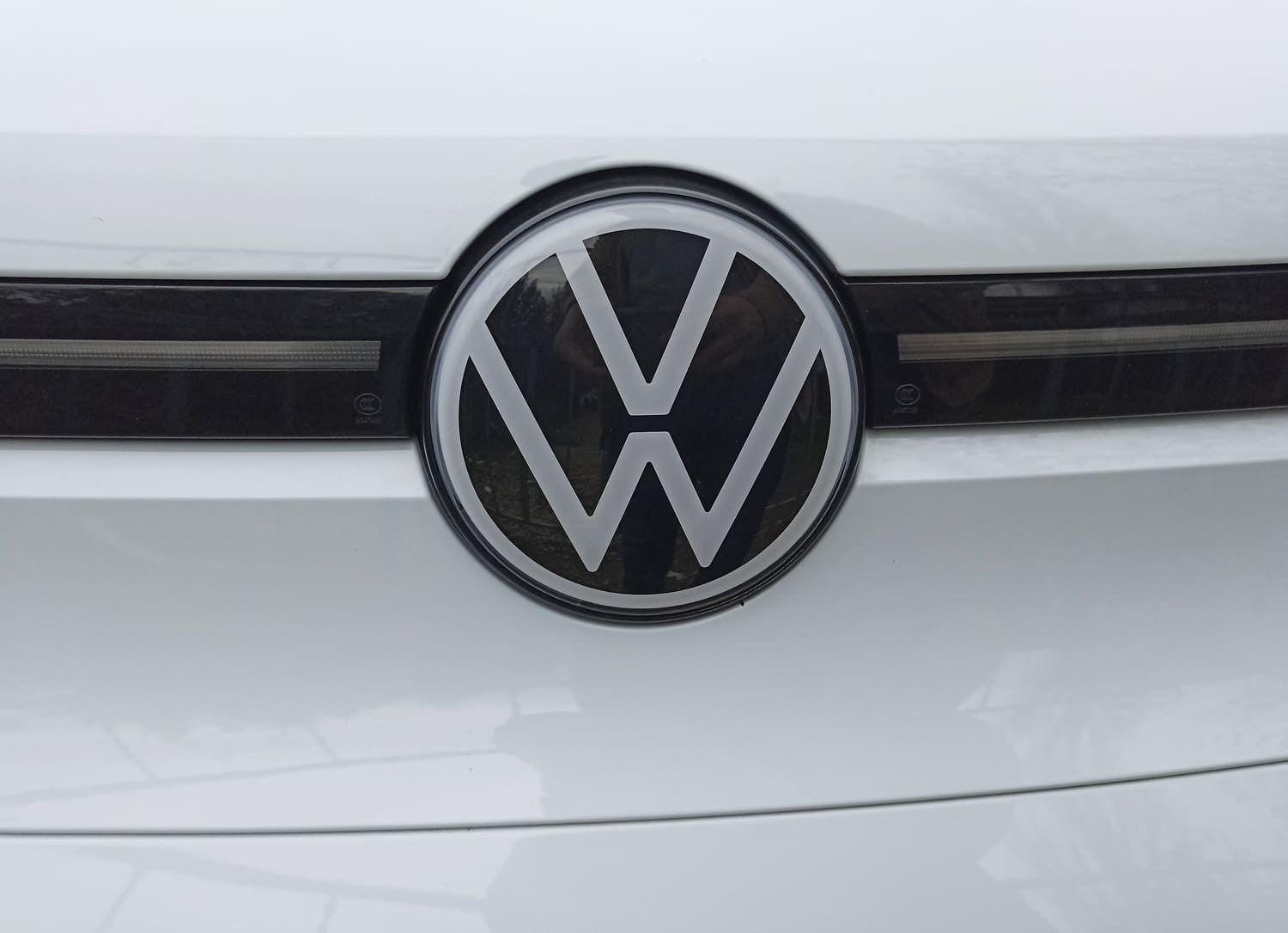 Close up of a VW badge on a white car