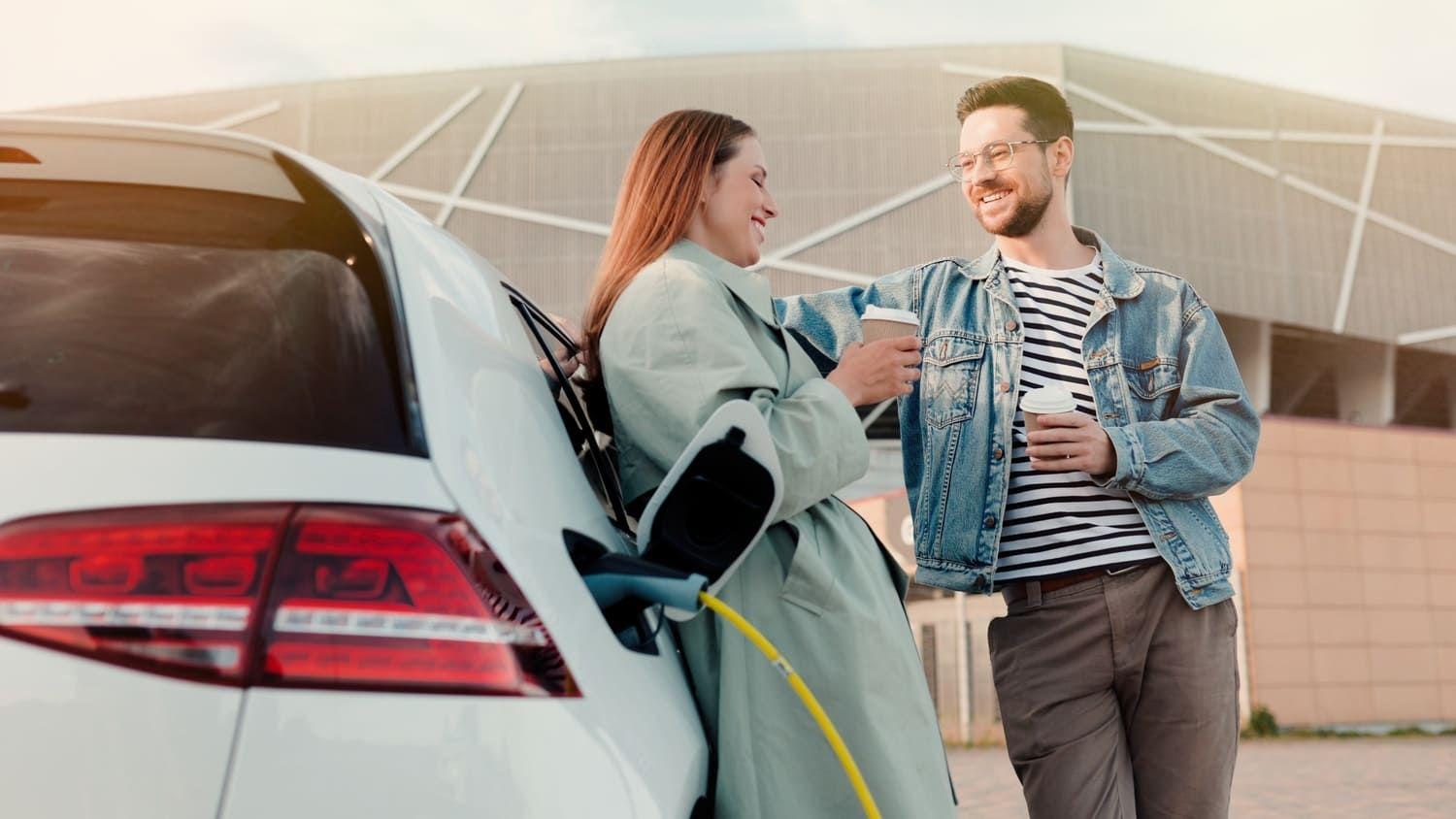 Couple stood next to a plug-in hybrid