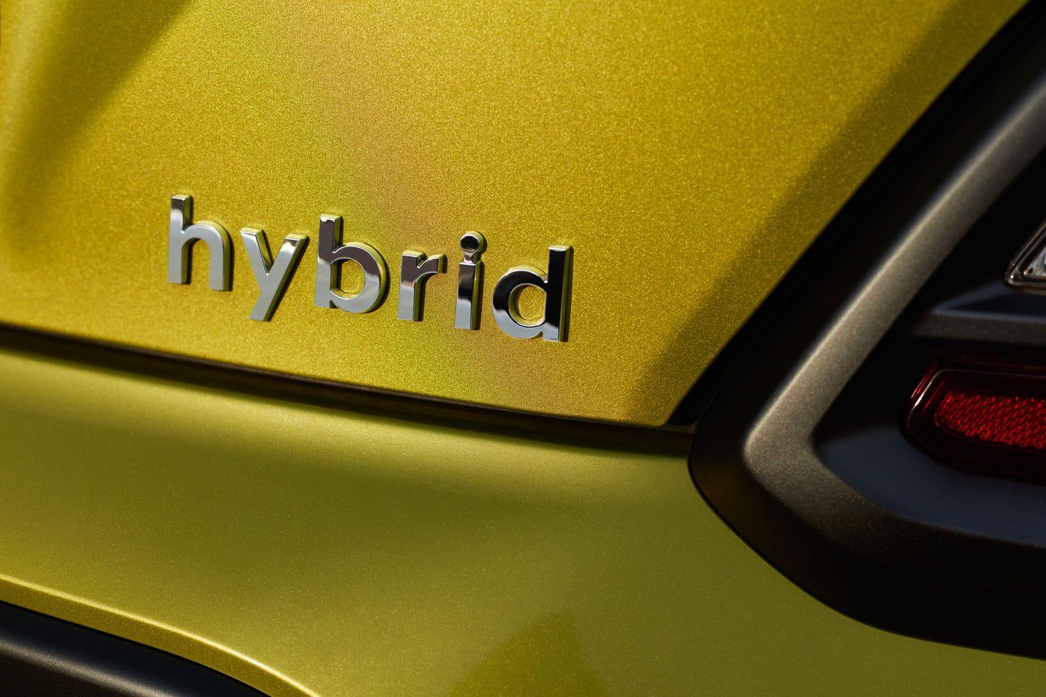 Silver hybrid badge on a yellow car